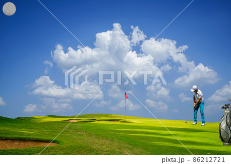 Golf player putting golf ball to hole during sunset or sunrise. Golf player putting golf ball to hole during sunset or sunrise. 86212721