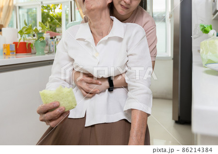 Asian senior woman with bread stuck in her throat,caregiver helping elderly people suffering from choking or food obstruction in the trachea in causing suffocation,emergency first aid,life saving 86214384