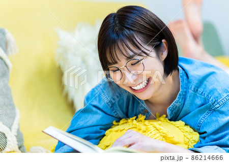 ソファで寝転んで読書する女性 86214666