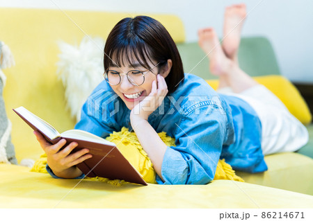 ソファで寝転んで読書する女性 86214671