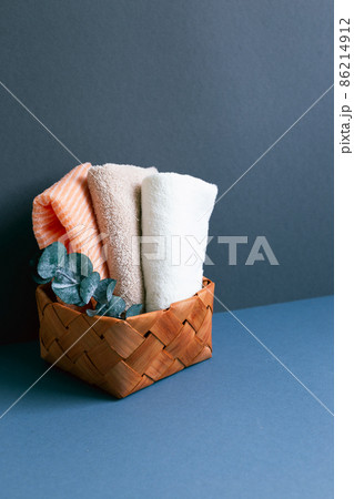 Bathroom towel in basket on table. navy blue wall background 86214912