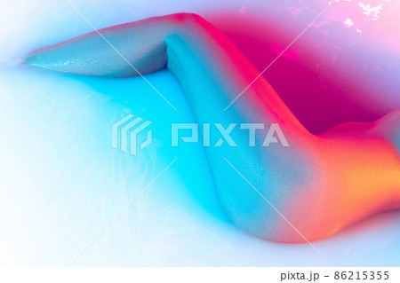Close up female hips, bottocks in the milk bath with soft blue neon glowing. Beauty, fashion, style, bodycare, spa concept. Close up female hips, bottocks in the milk bath with soft blue neon glowing. Beauty, fashion, style, bodycare, spa concept. 86215355