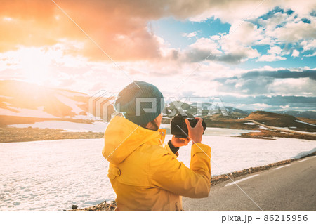 Aurlandsfjellet, Norway. Young Happy Woman Tourist Traveler Photographer Taking Pictures Photos Of Aurlandsfjellet Scenic Route Road. Norwegian Landmark And Popular Destination Aurlandsfjellet, Norway. Young Happy Woman Tourist Traveler Photographer Taking Pictures Photos Of Aurlandsfjellet Scenic Route Road. Norwegian Landmark And Popular Destination 86215956