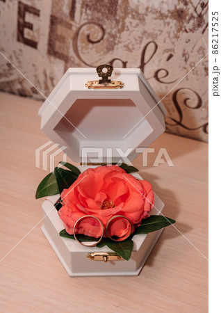 Wedding gold rings on an orange rose in a white box 86217525