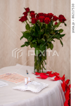 Wedding rings on a pillow for rings on a background of a bouquet of red roses 86217530