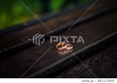 Wedding rings on a wooden stand against the background of the bride's bouquet Wedding rings on a wooden stand against the background of the bride's bouquet 86217849