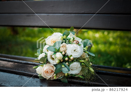 Wedding gold rings on a bouquet with white roses 86217924