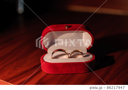Wedding gold rings in a red box on a brown background 86217947