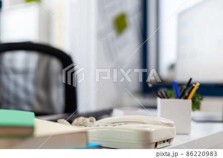 Closeup of phone on desk in empty business office. Closeup of phone on desk in empty business office. 86220983