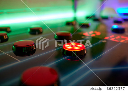 Joystick and button controls of a vintage arcade video game in a dark room. 86222577