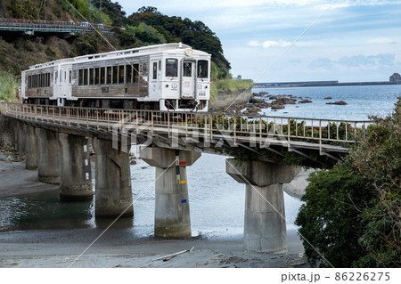 南九州の青空と青い海そして自然の力で作られた奇岩に打ち付ける波風をうけて走る白い日南線特急海幸山幸 86226275