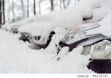 Snowfall in the city. Car covered in several inches of snow. Car almost totally buried 86226767