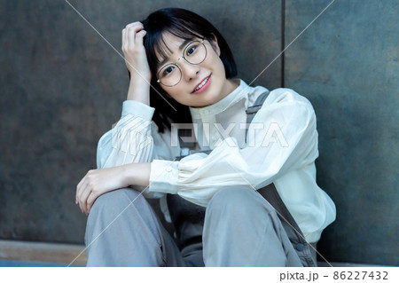 部屋で寛ぐ眼鏡の若い女性 86227432