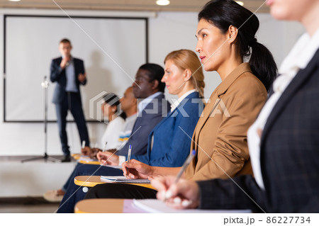 Confident woman listening to lecture at conference 86227734