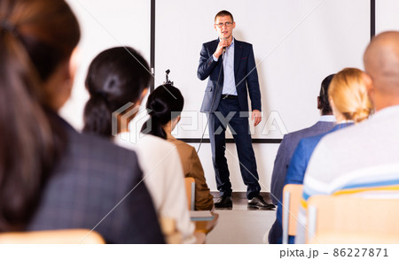 Business coach speaking from stage to audience at corporate training Business coach speaking from stage to audience at corporate training 86227871