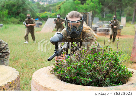 Portrait of girl in camouflage on paintball field Portrait of girl in camouflage on paintball field 86228022