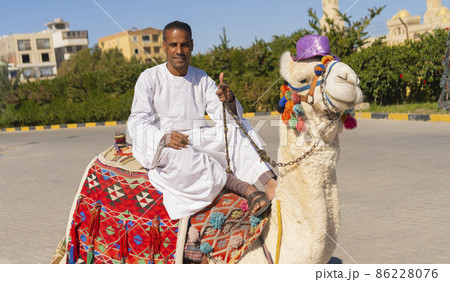 Arab man sitting on a camel in a touristic area. 86228076