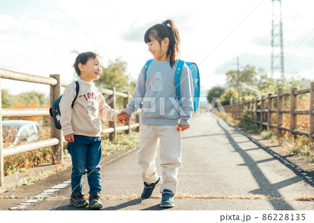 手を繋いで笑顔をみせる子供 Innocent 手を繋いで笑顔をみせる子供 Innocent 86228135