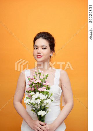 Beautiful woman Cute Asian girl feeling happy holding floral bouquet on yellow background - Beautiful woman lifestyle 86229355