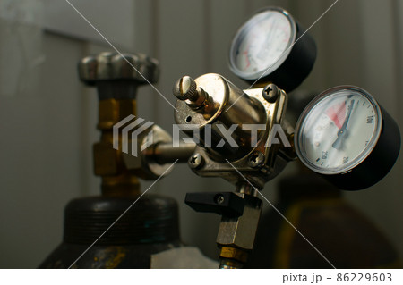 view of switch devices, indicators and a gas pressure regulator, liquids mounted on a metal gas cylinder view of switch devices, indicators and a gas pressure regulator, liquids mounted on a metal gas cylinder 86229603