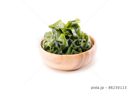 Fresh seaweed wakame in woodle bowl isolated on white background. Copy space. Japanese food 86230113