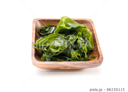 Fresh seaweed wakame in woodle bowl isolated on white background. Copy space. Japanese food Fresh seaweed wakame in woodle bowl isolated on white background. Copy space. Japanese food 86230115