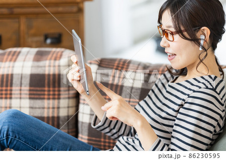 タブレット端末の画面を見ている普段着の女性 タブレット端末の画面を見ている普段着の女性 86230595