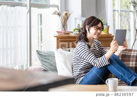 タブレット端末の画面を見ている普段着の女性 タブレット端末の画面を見ている普段着の女性 86230597