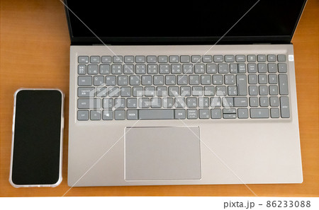 木製テーブル上のノートパソコンとスマートフォン 木製テーブル上のノートパソコンとスマートフォン 86233088