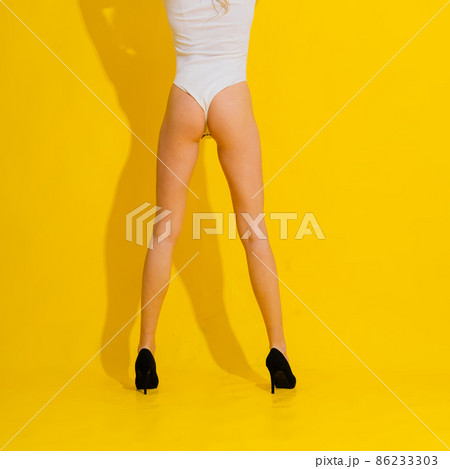 Beautiful woman legs in high heels, white bodysuit panties - studio Beautiful woman legs in high heels, white bodysuit panties - studio 86233303