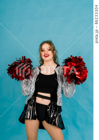 Beautiful young adult cheerleader female, studio red and blue background 86233304