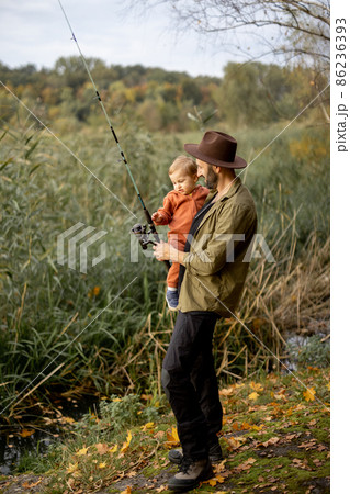 Man fishing with little son on lake coast 86236393