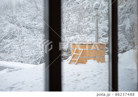 Wooden hot vat on snowy terrace at mountains 86237488