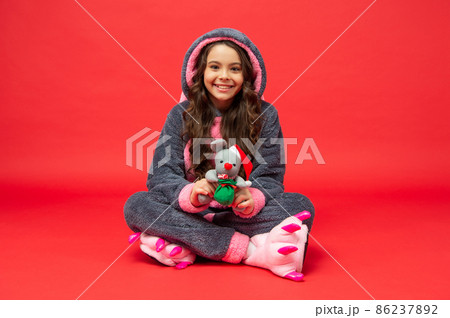 happy child in cozy sleepwear with christmas toy. sweet dreams. comfortable pajama happy child in cozy sleepwear with christmas toy. sweet dreams. comfortable pajama 86237892