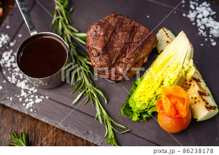 Black Angus Chateaubriant steak. Tenderloin from Brazil. Delicious healthy traditional food closeup served for lunch in modern gourmet cuisine restaurant Black Angus Chateaubriant steak. Tenderloin from Brazil. Delicious healthy traditional food closeup served for lunch in modern gourmet cuisine restaurant 86238178