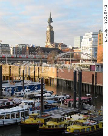 港町ハンブルクの運河に浮かぶ船と聖ミヒャエル教会の時計塔 86238742