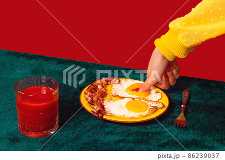Human hand tasting bacon and eggs isolated on green and red background. Vintage, retro style interior. Food pop art photography. 86239037