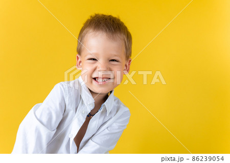 Banner Funny Preschool Child Boy in unbuttoned shirt smile narrow eye on Yellow Background Copy Space. Happy Smiling Kid Go Back to School, Kindergarten. Success, Motivation, Genius, Superhero concept 86239054