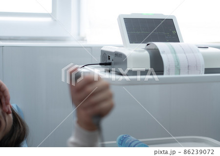 Close Up Pregnant Woman On Hospital Couch During Medical Control Cardiotocography. Visit Gynecologist Doctor At Clinic For Pregnancy Consultant. Examine Expectant Belly Baby Mother Healthcare Check Up 86239072