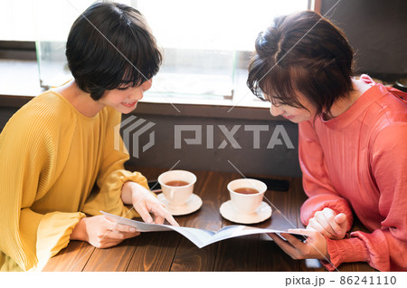 カフェでパンフレットを見て旅行プランを練る二人の女性 撮影協力「洋菓子店 sentiment」 カフェでパンフレットを見て旅行プランを練る二人の女性 撮影協力「洋菓子店 sentiment」 86241110
