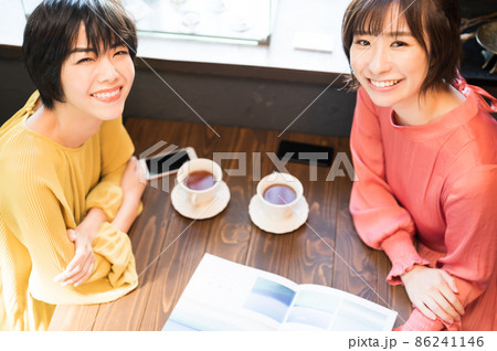 カフェでパンフレットを見て旅行プランを練る二人の女性 撮影協力「洋菓子店 sentiment」 カフェでパンフレットを見て旅行プランを練る二人の女性 撮影協力「洋菓子店 sentiment」 86241146