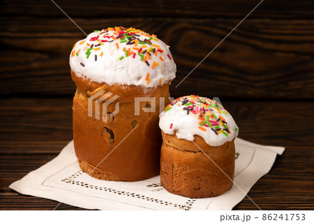 Traditional Easter russian orthodox cakes kuliches on a vintage white cloth napkin on wooden boards Traditional Easter russian orthodox cakes kuliches on a vintage white cloth napkin on wooden boards 86241753