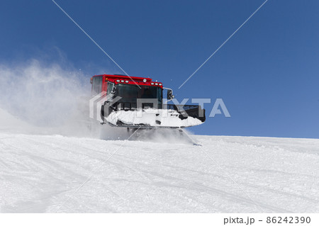 Snowcat on a slope high up in the mountains Snowcat on a slope high up in the mountains 86242390
