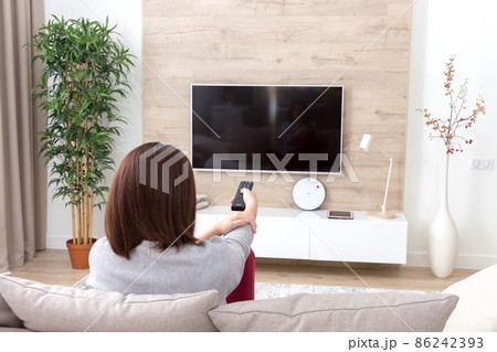 Young woman watching TV in the room 86242393