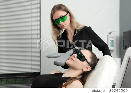 Young woman receiving laser treatment in cosmetology clinic 86242509