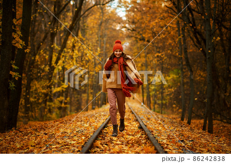 Woman walking in autumn forest Woman walking in autumn forest 86242838