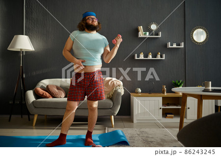 Funny man doing morning workout with dumbbells 86243245