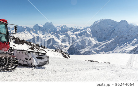 Snowcat on a slope high up in the mountains 86244064