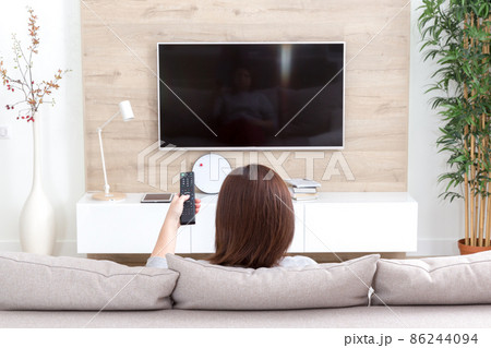 Young woman watching TV in the room Young woman watching TV in the room 86244094