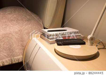 Smartphone in black case charging wireless on bed table 86244445